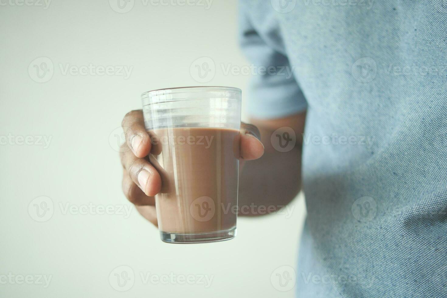 man hand holding glass of chocolate milk photo