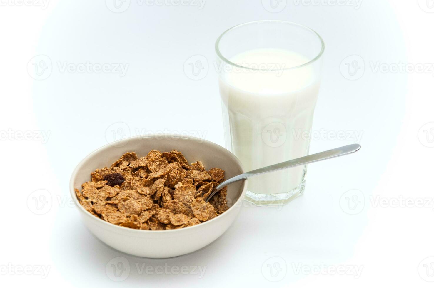 Glass of milk and bowl of brown cereals photo