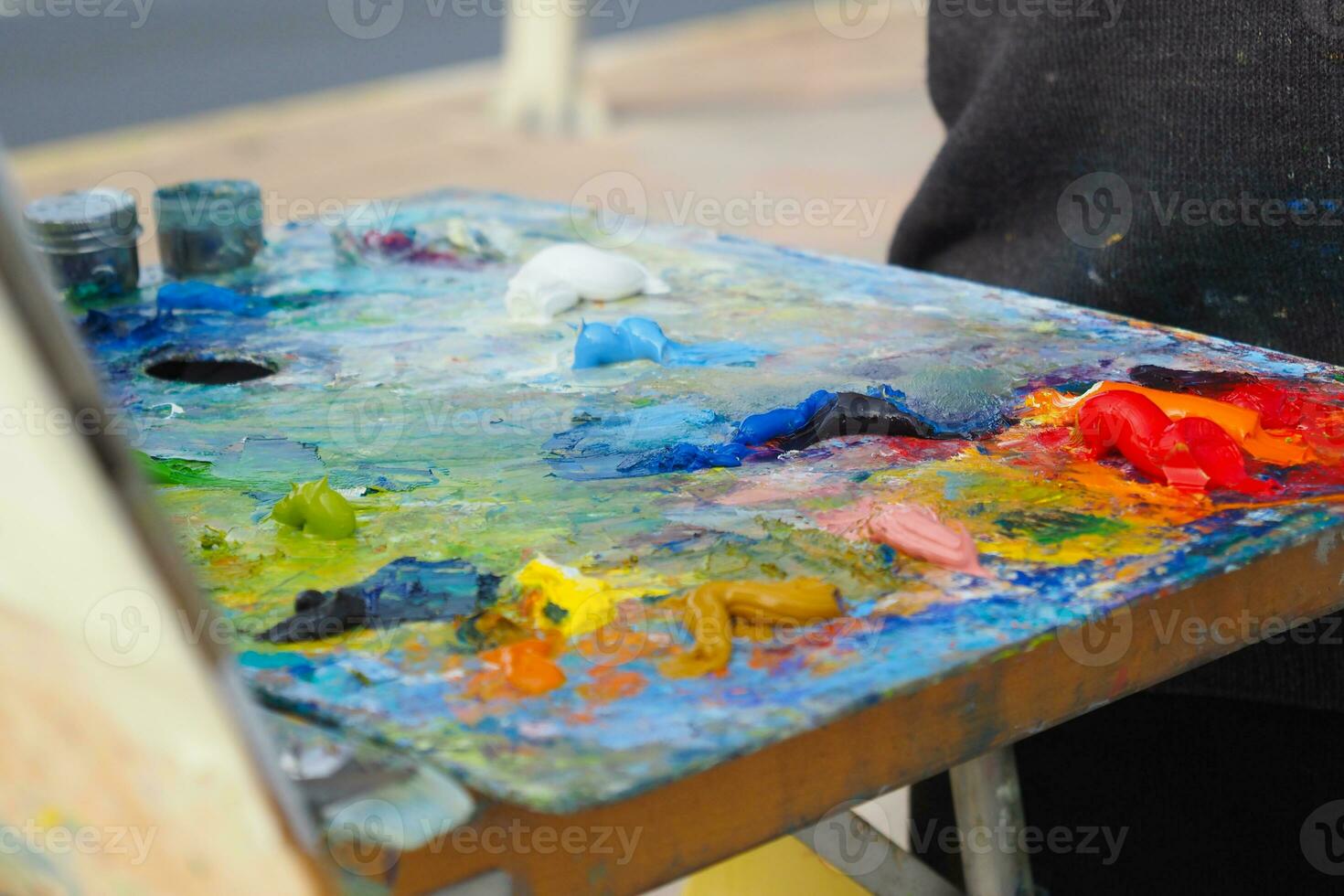Colorful palette with oil painting and brushes photo