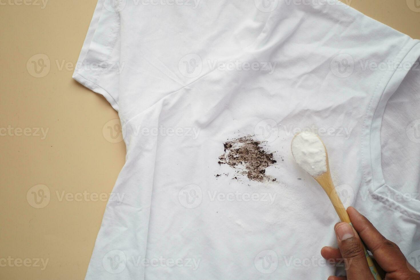 hand removing stain on clothes with biocarbonat photo