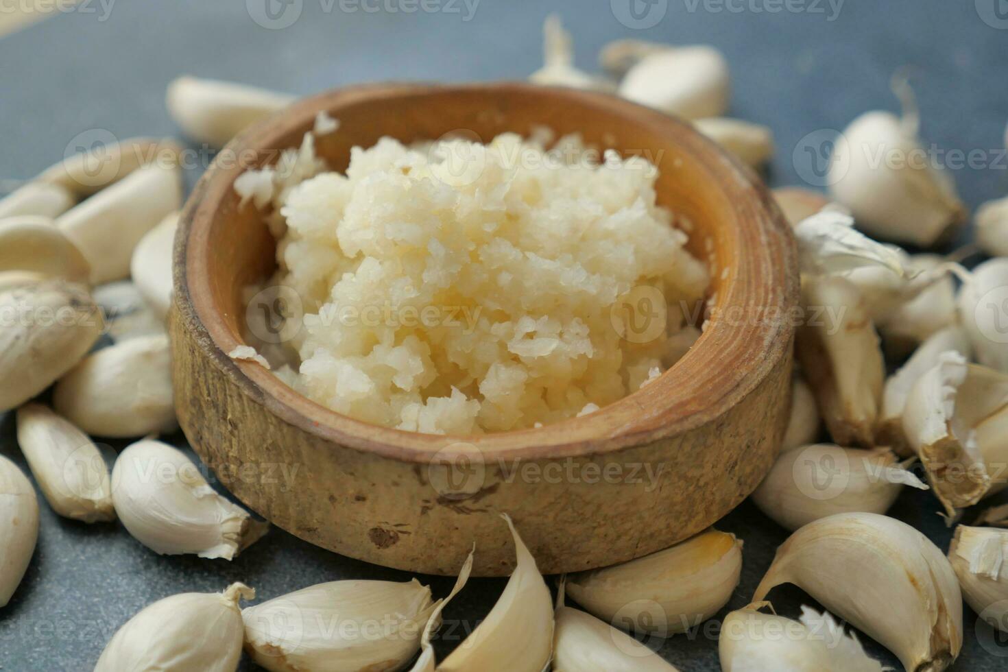 close up of minced garlic on a wooden spoon photo