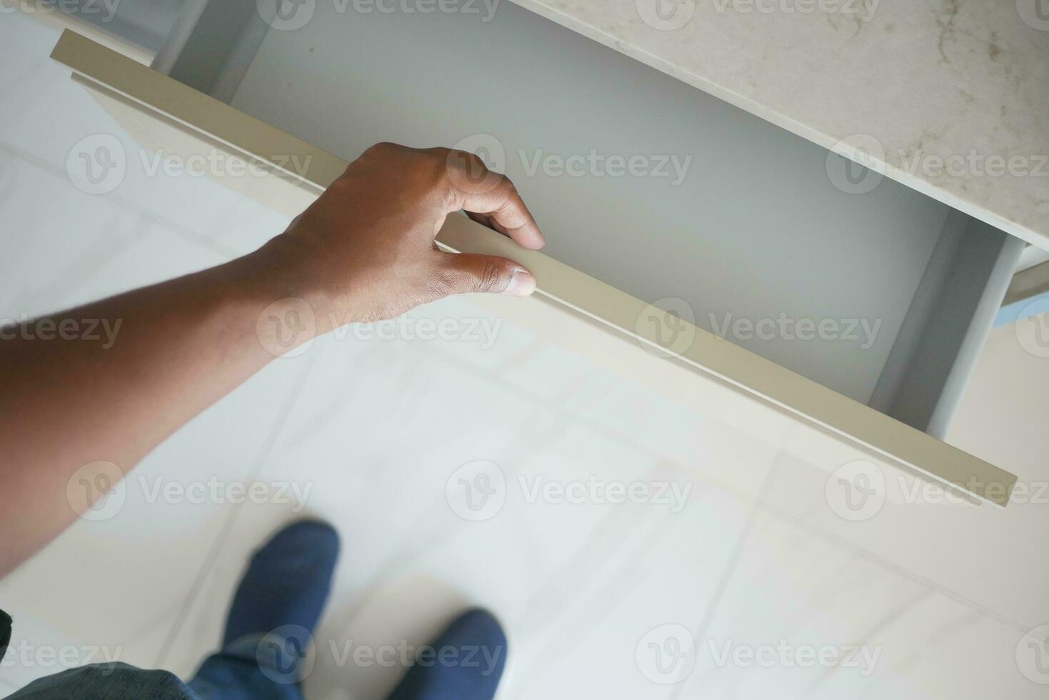 man's hand open drawer wooden in cabinet photo