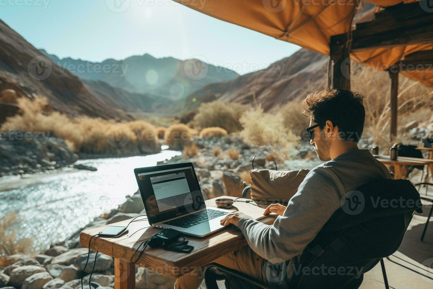 AI generated man working in front of laptop in beautiful place photo