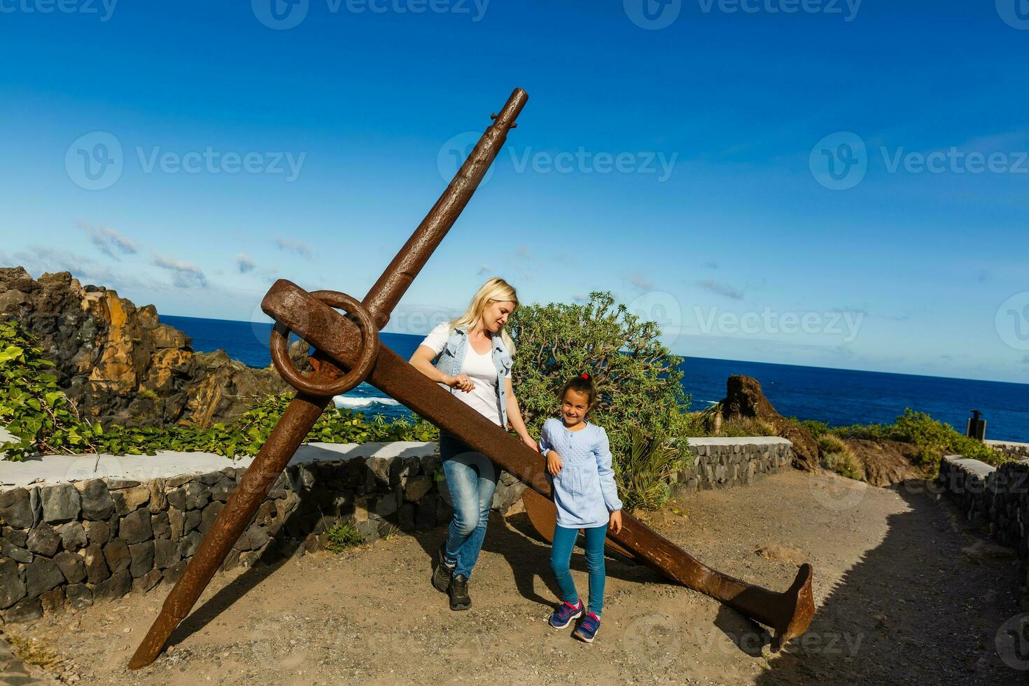 Young girl smiling and speaking consulting and giving instruction with voice recognition. Woman with audio recording in smart phone in the seaside in Garachico, Tenerife photo