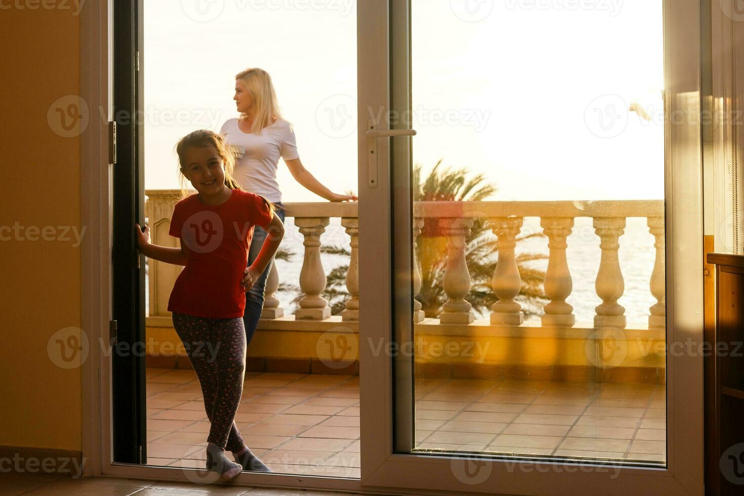 Woman near window facing the sunrise at morning photo