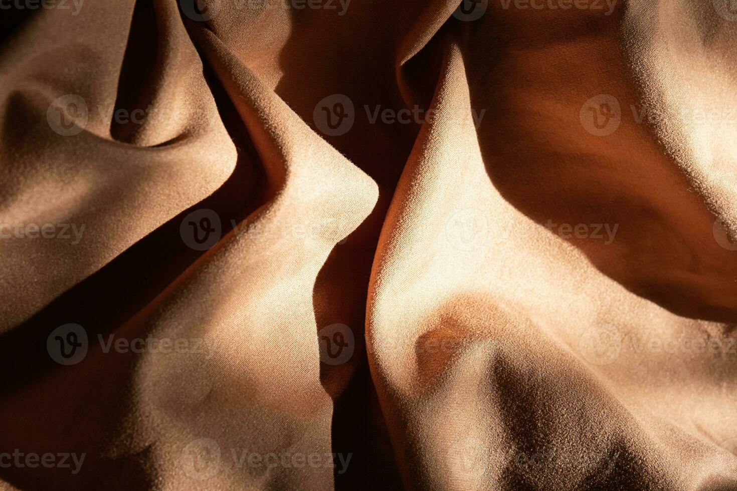 Brown textured wavy fabric in hard light. photo