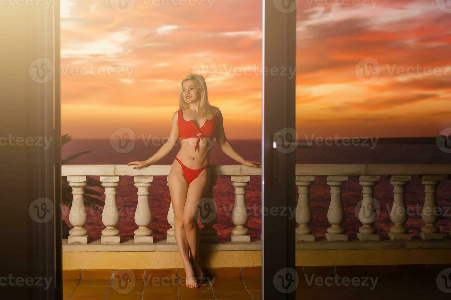 Woman admiring sunset from her balcony photo