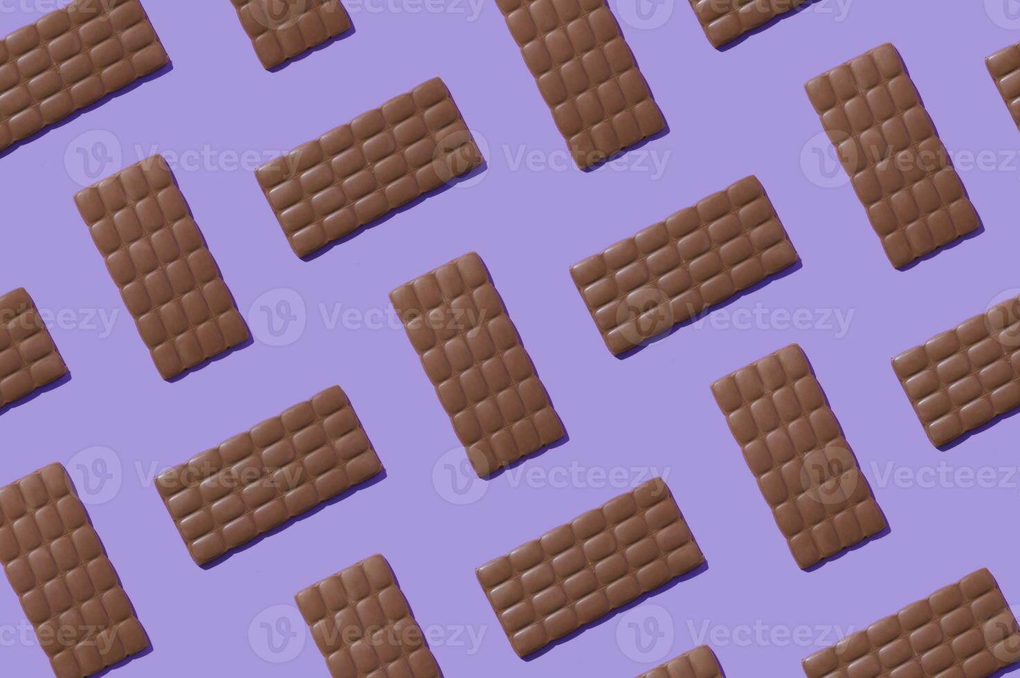 Creative trendy pattern made with delicious chocolates on light purple background. Minimal concept. Yummy chocolate bars composition. Tasty sweet food idea. Chocolate aesthetic pattern background. photo