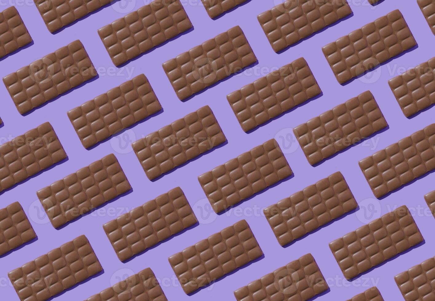 Creative trendy pattern made with delicious chocolates on light purple background. Minimal concept. Yummy chocolate bars composition. Tasty sweet food idea. Chocolate aesthetic pattern background. photo