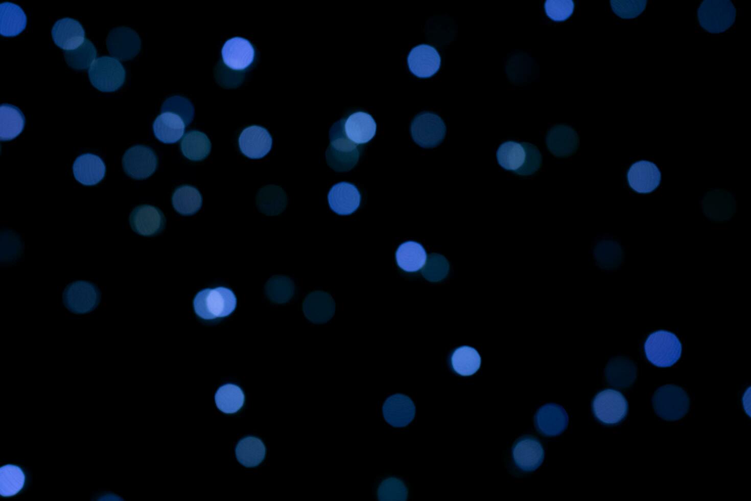 Blue round blurred bokeh lights for a festive background. defocused image photo