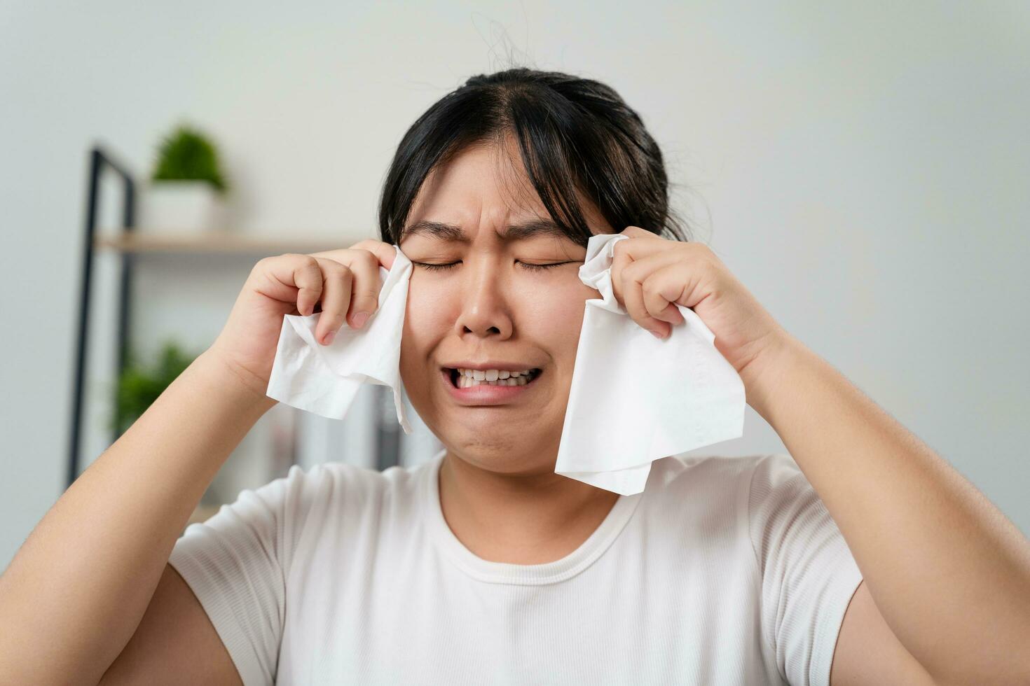 Portrait of a Sad Asian woman crying wipes her tears with a tissue paper towel. photo