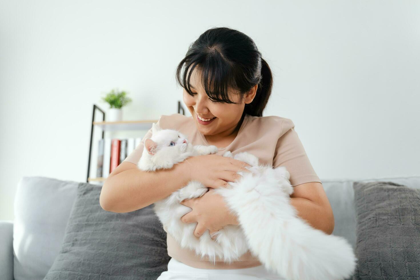 Happy Woman Playing with Cat in Cozy Living Room at Home. photo