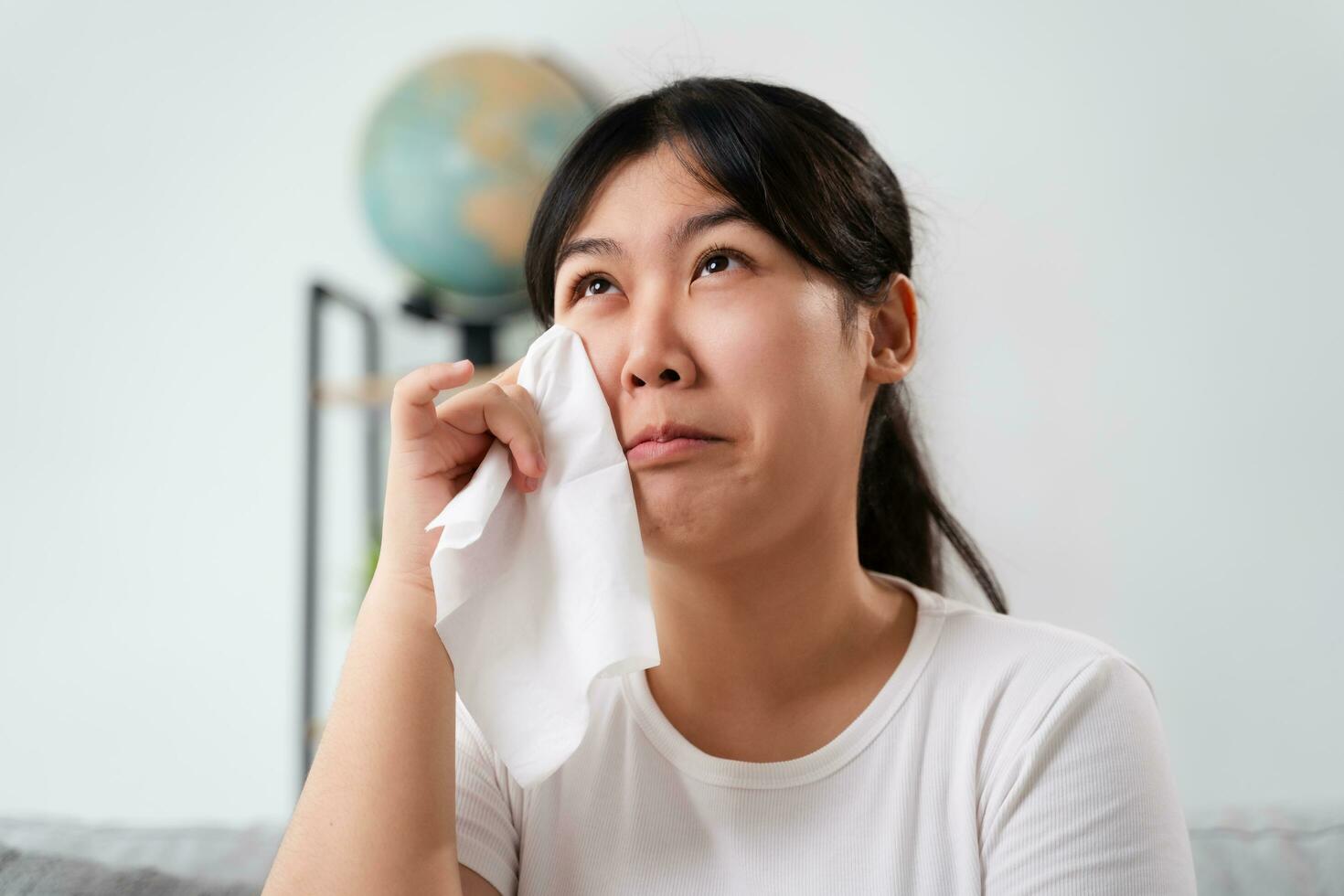 Portrait of a Sad Asian woman crying wipes her tears with a tissue paper towel. photo