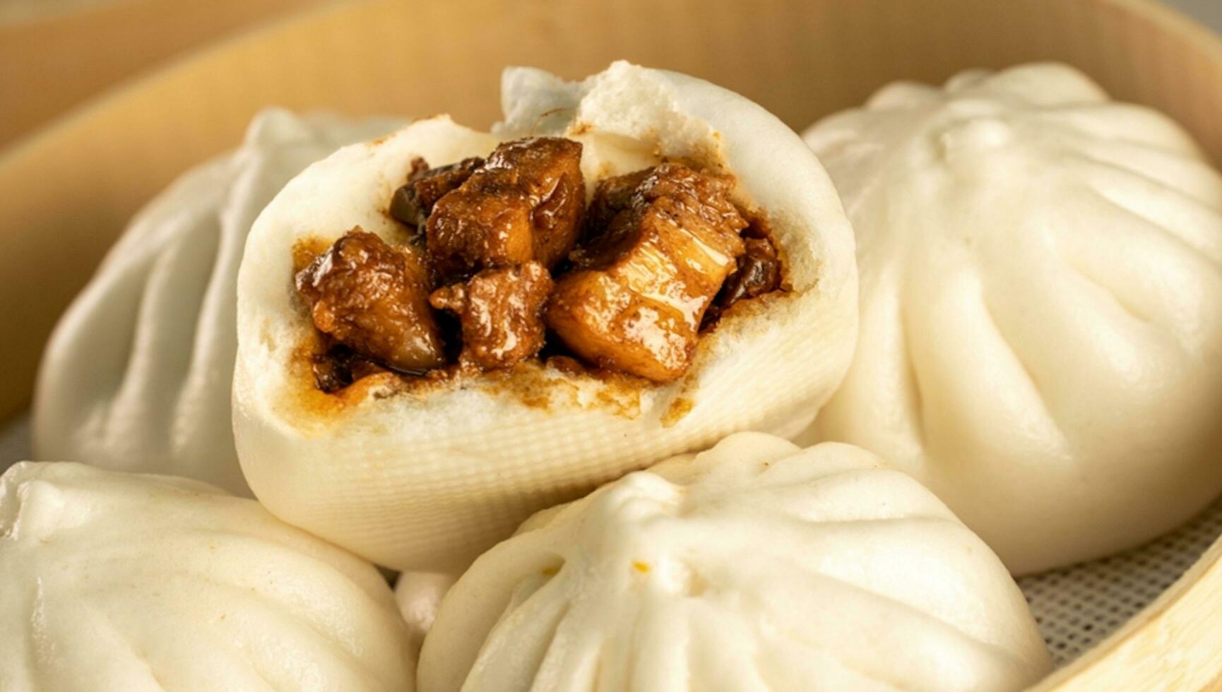 Chinese food, Baozi is a traditional delicacy in China, Bread Food Photography So Tempting, Delicious baozi, Chinese steamed meat bun is ready to eat on serving plate and steamer photo