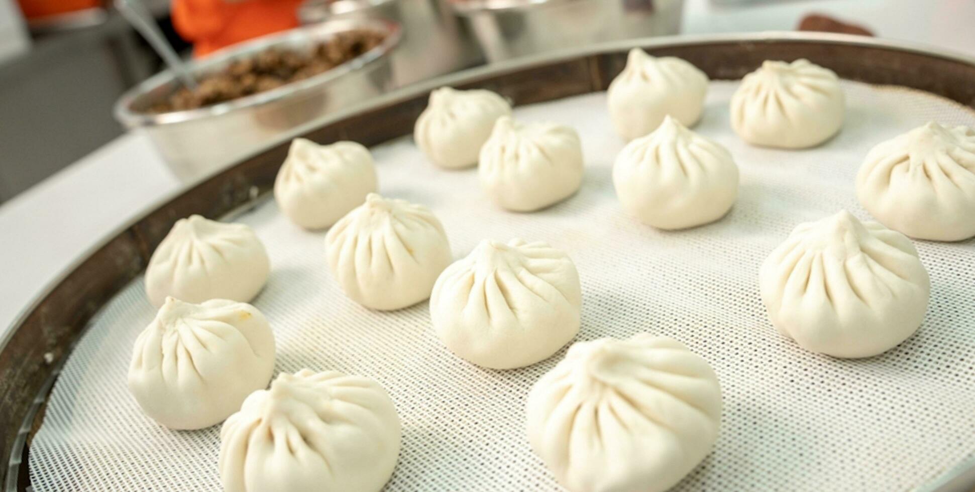 Chinese food, Baozi is a traditional delicacy in China, Bread Food Photography So Tempting, Delicious baozi, Chinese steamed meat bun is ready to eat on serving plate and steamer photo