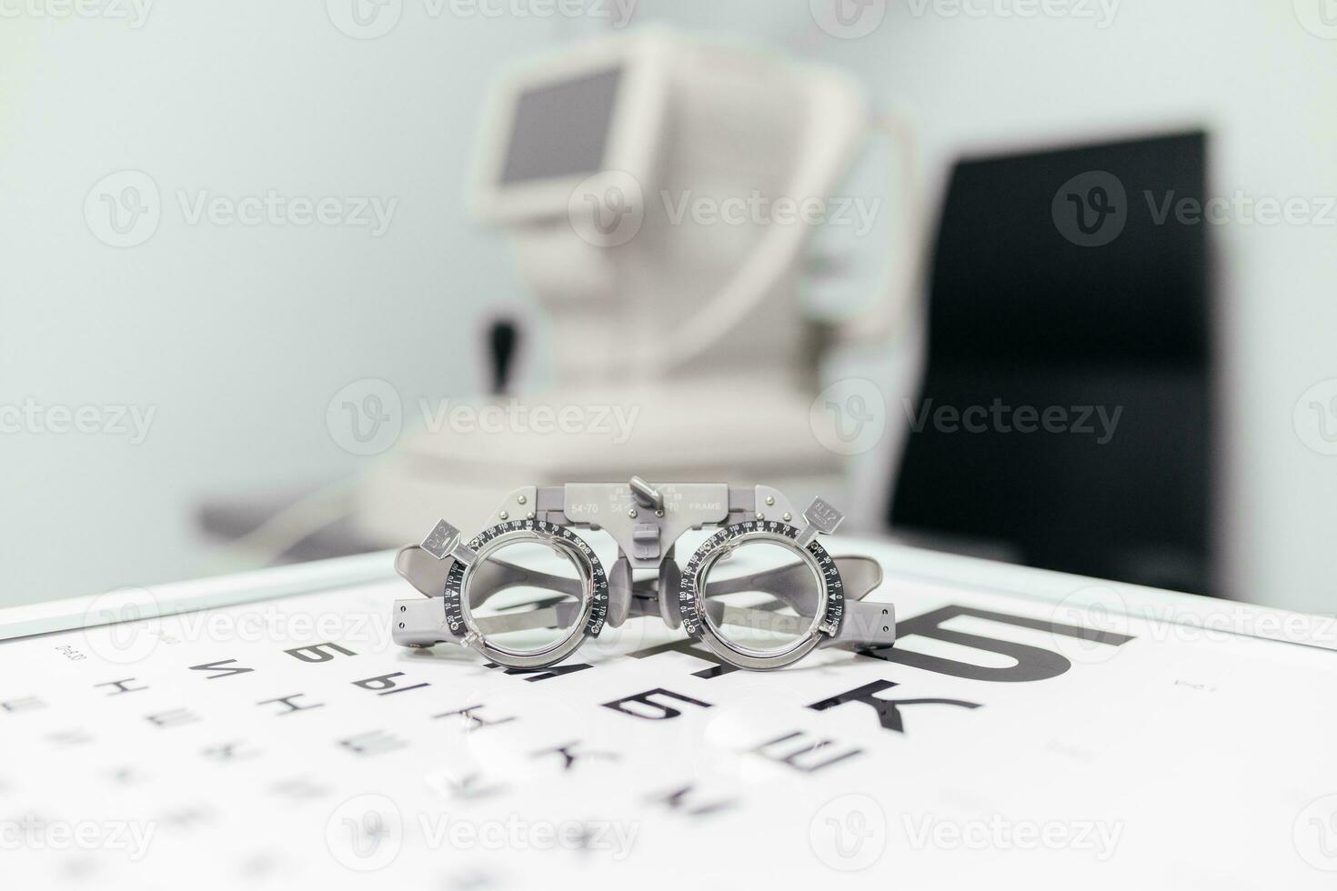 Glasses for checking eyesight. Eyeglasses selection on modern diagnostic equipment in an ophthalmic clinic. Eye test chart with glasses. photo