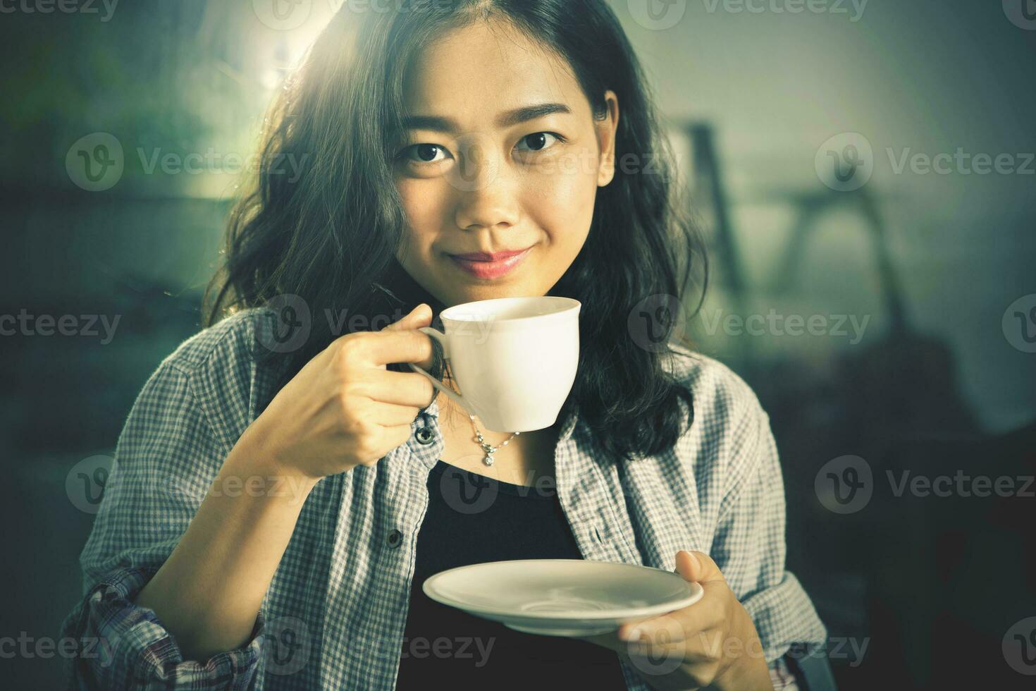 cerca arriba cara de asiático mujer con caliente café taza Listo a bebida en mano cine color proceso foto
