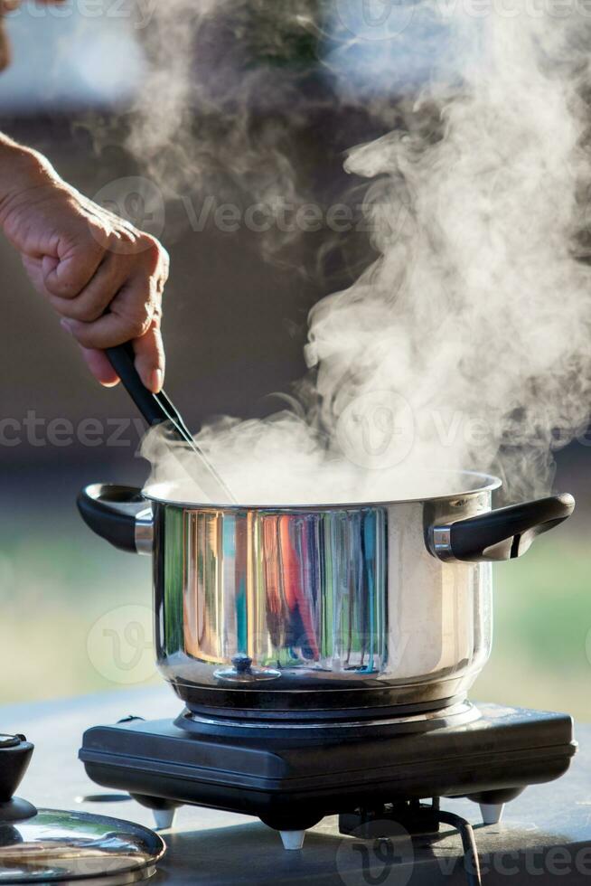 hand cooking on hot pot with water steam photo