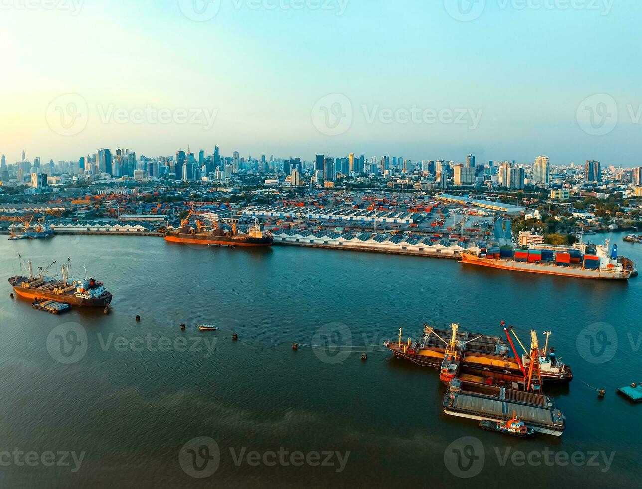 aerial view of commercial ship and container dock  in chaopraya river with urban skyline in bangkok thailand capital photo