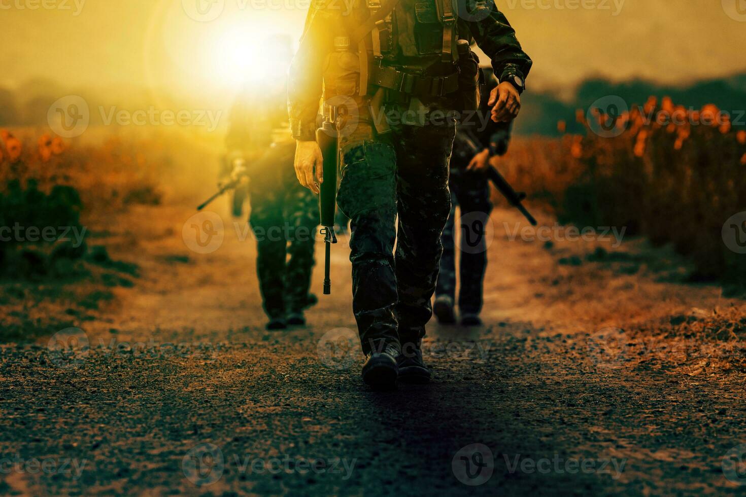soldier with long rifle gun walking on dirt battle field photo