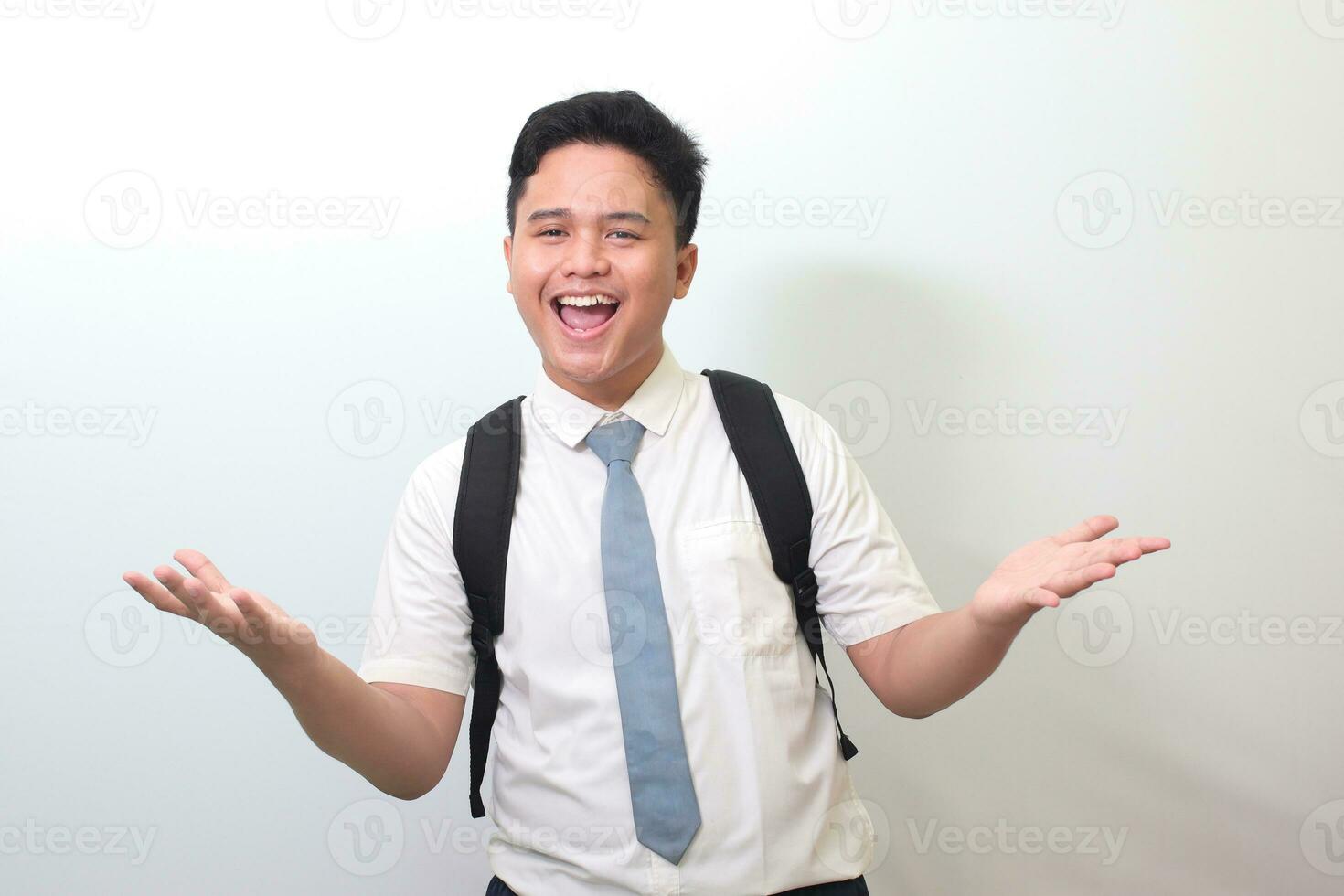 Indonesian senior high school student wearing white shirt uniform with gray tie pulling hands towards camera, inviting someone to come inside, welcoming gesture. Isolated image on white background photo