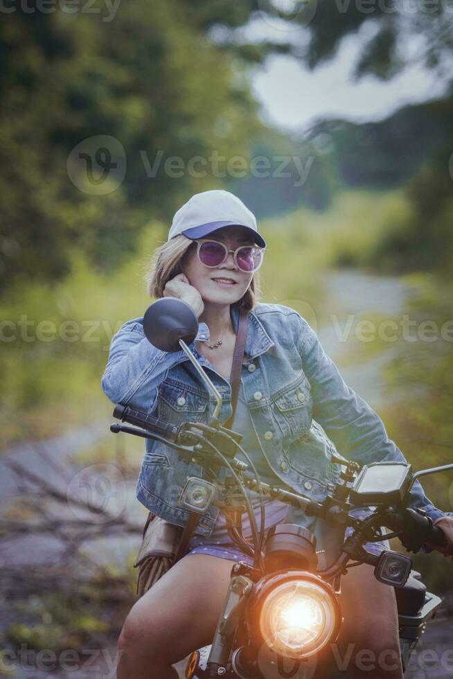 pretty woman riding sport enduro motorcycle on dirt field photo