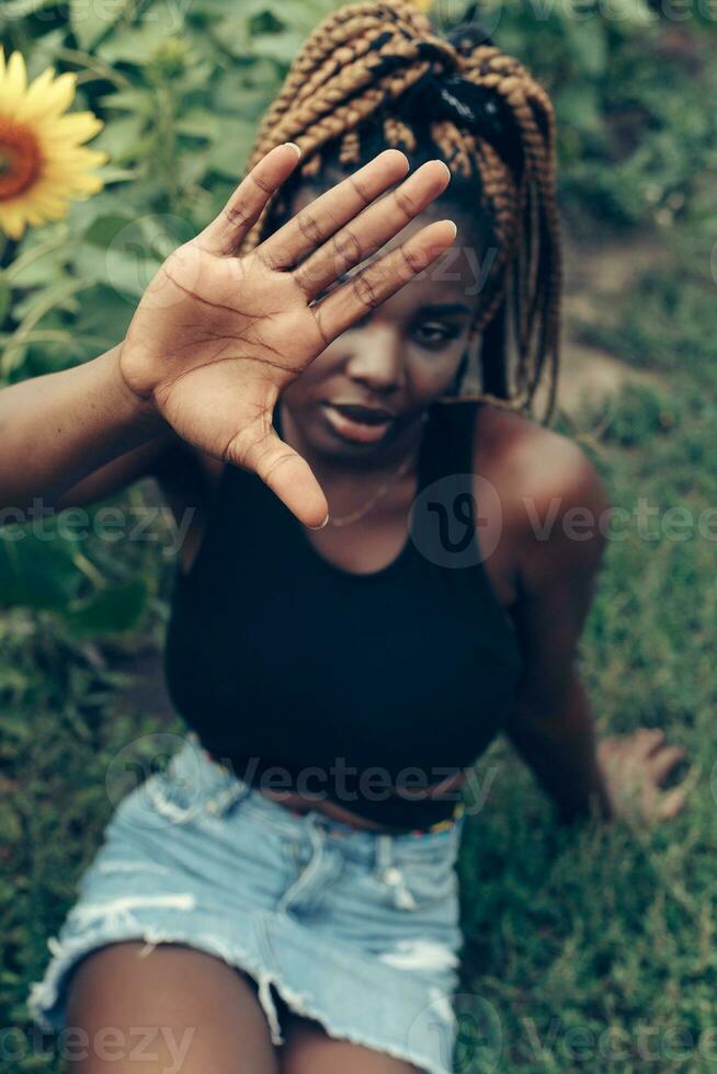 African American girl in a field of yellow flowers at sunset photo