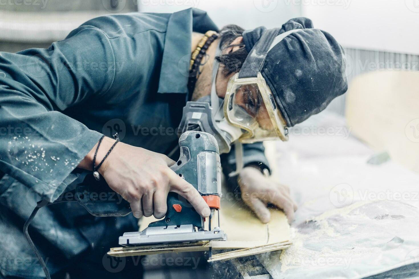 A carpenter cuts a board with an electric jigsaw. photo