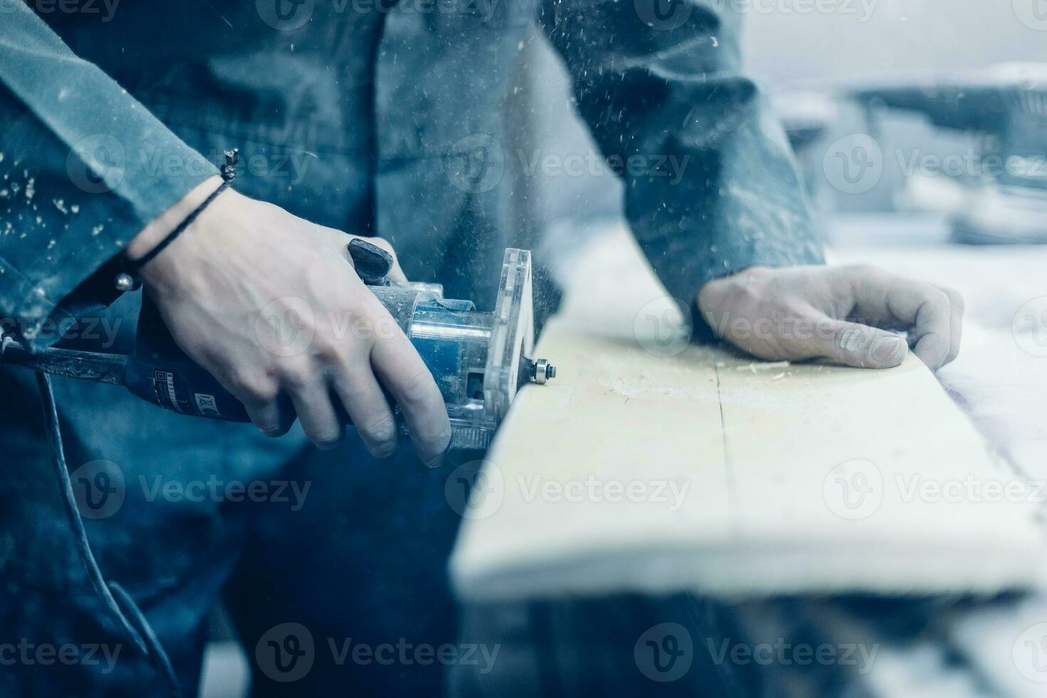 A carpenter cuts a board with an electric jigsaw. photo