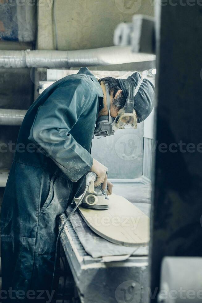 A carpenter cuts a board with an electric jigsaw. photo
