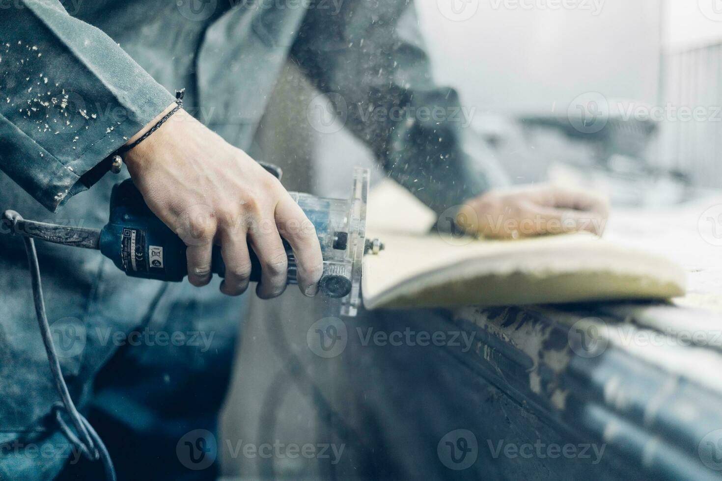 A carpenter cuts a board with an electric jigsaw. photo