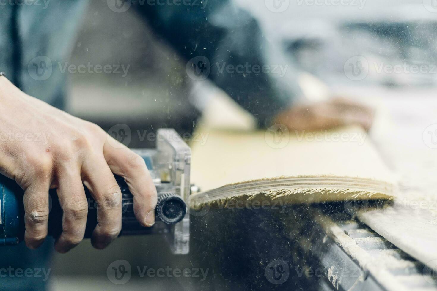 A carpenter cuts a board with an electric jigsaw. photo