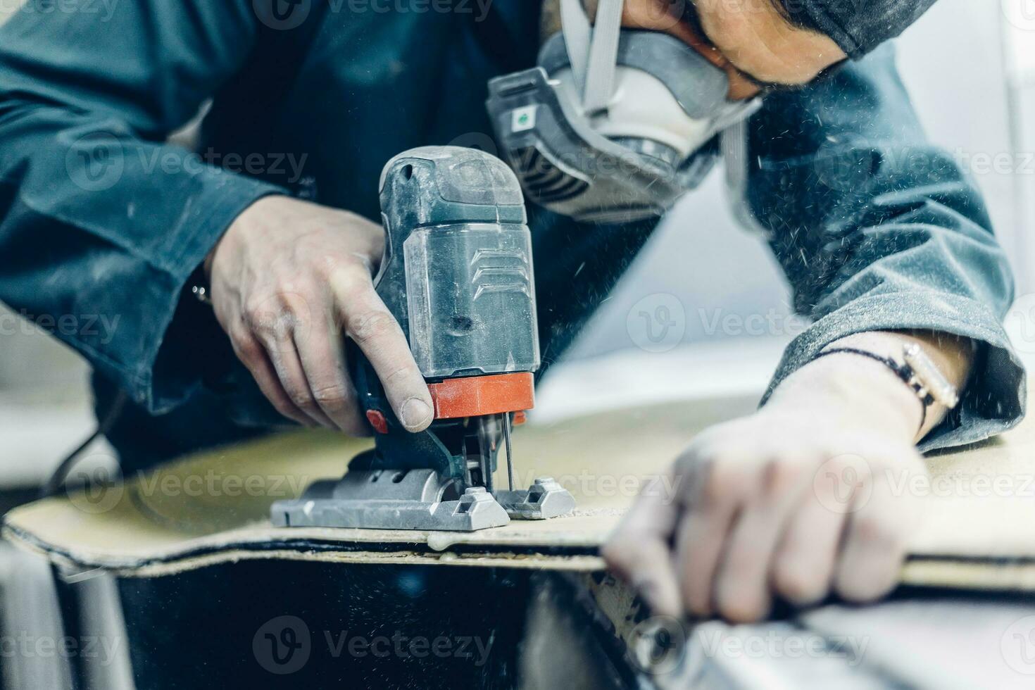 A carpenter cuts a board with an electric jigsaw. photo