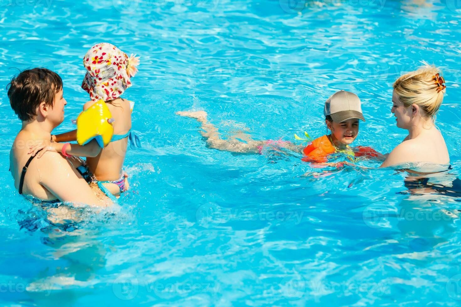 dos mujer y su niños en el piscina foto