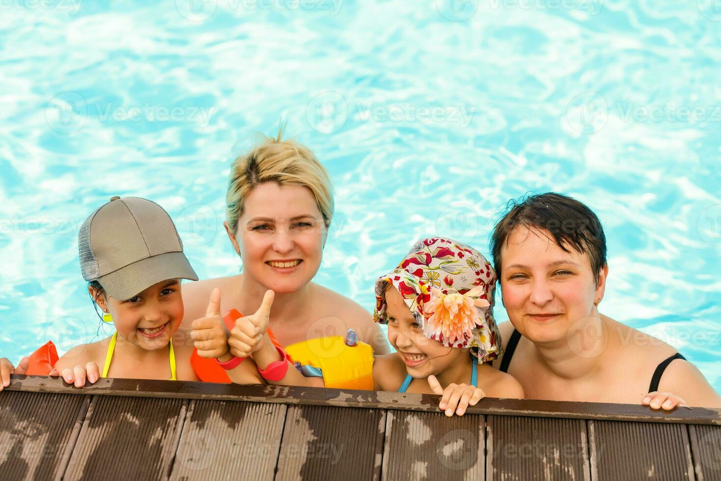 two women and their children in the pool photo