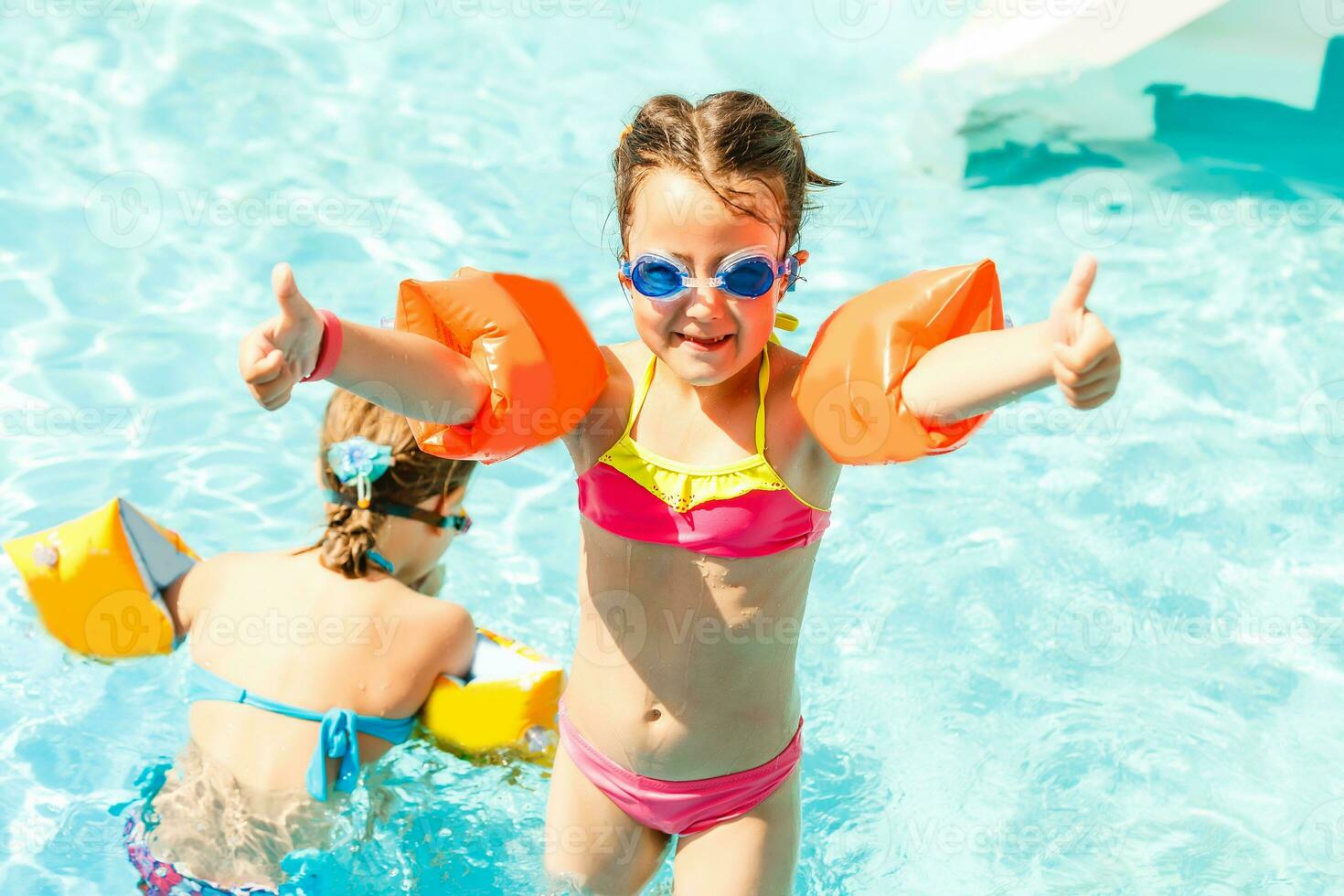 Cute toddler girl playing in swimming pool photo