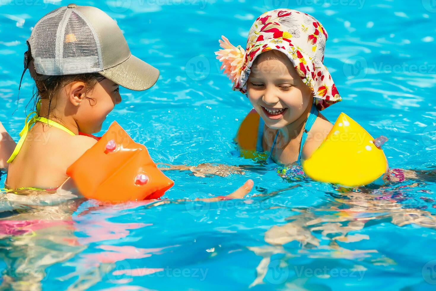 two women and their children in the pool photo