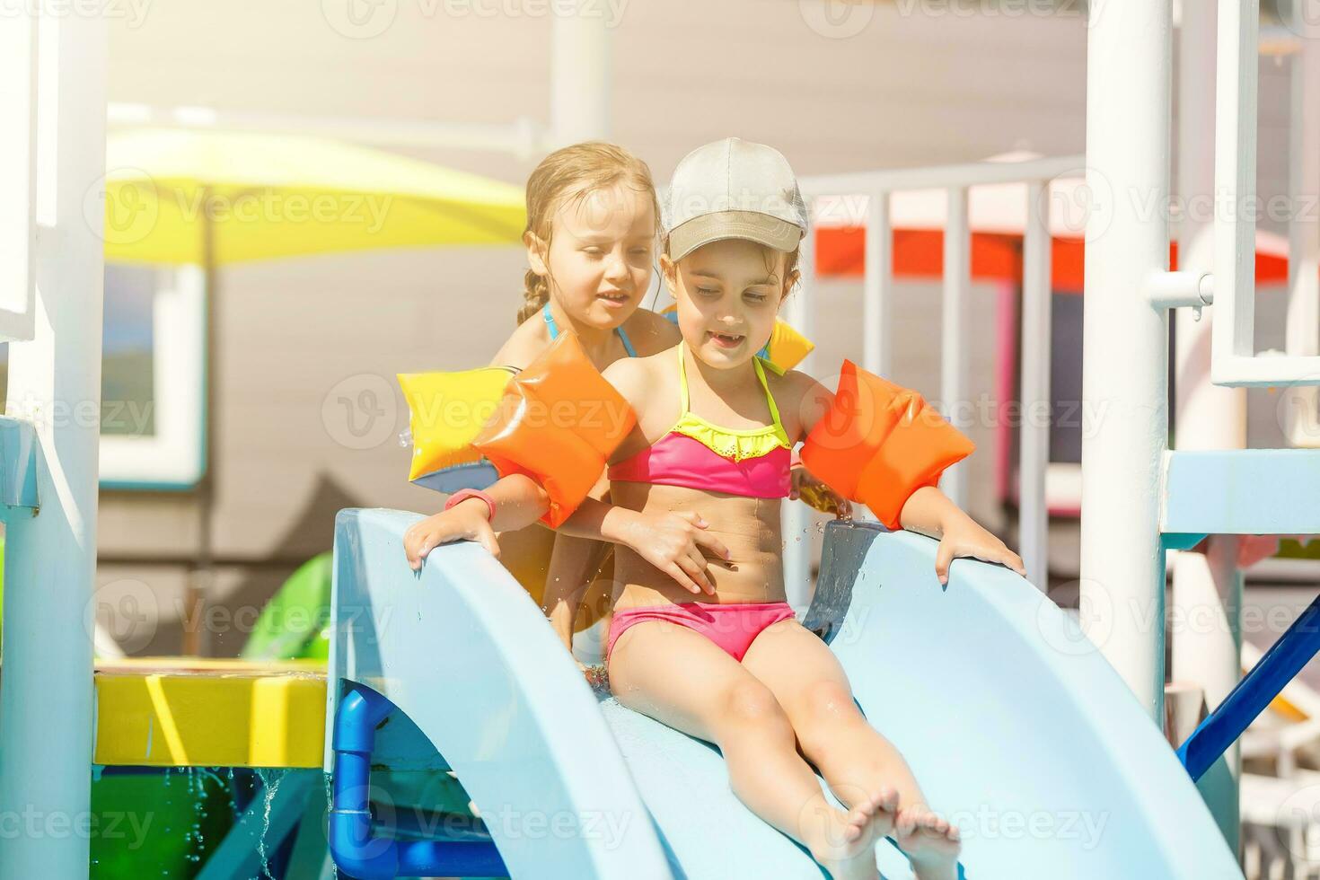 dos pequeño muchachas jugando en el piscina foto