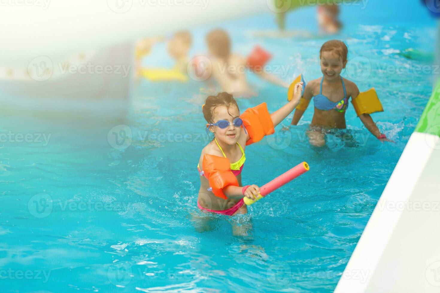 Cute toddler girl playing in swimming pool photo