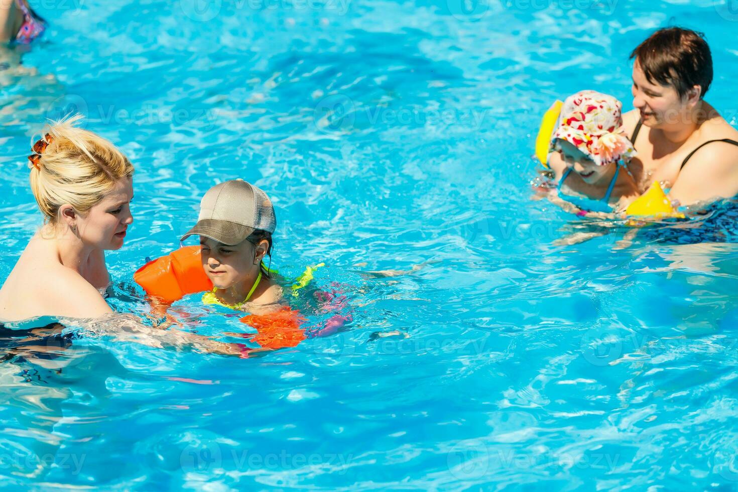 dos mujer y su niños en el piscina foto