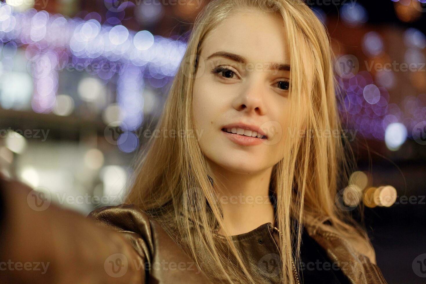woman smiling in the night against evening lights bokeh photo