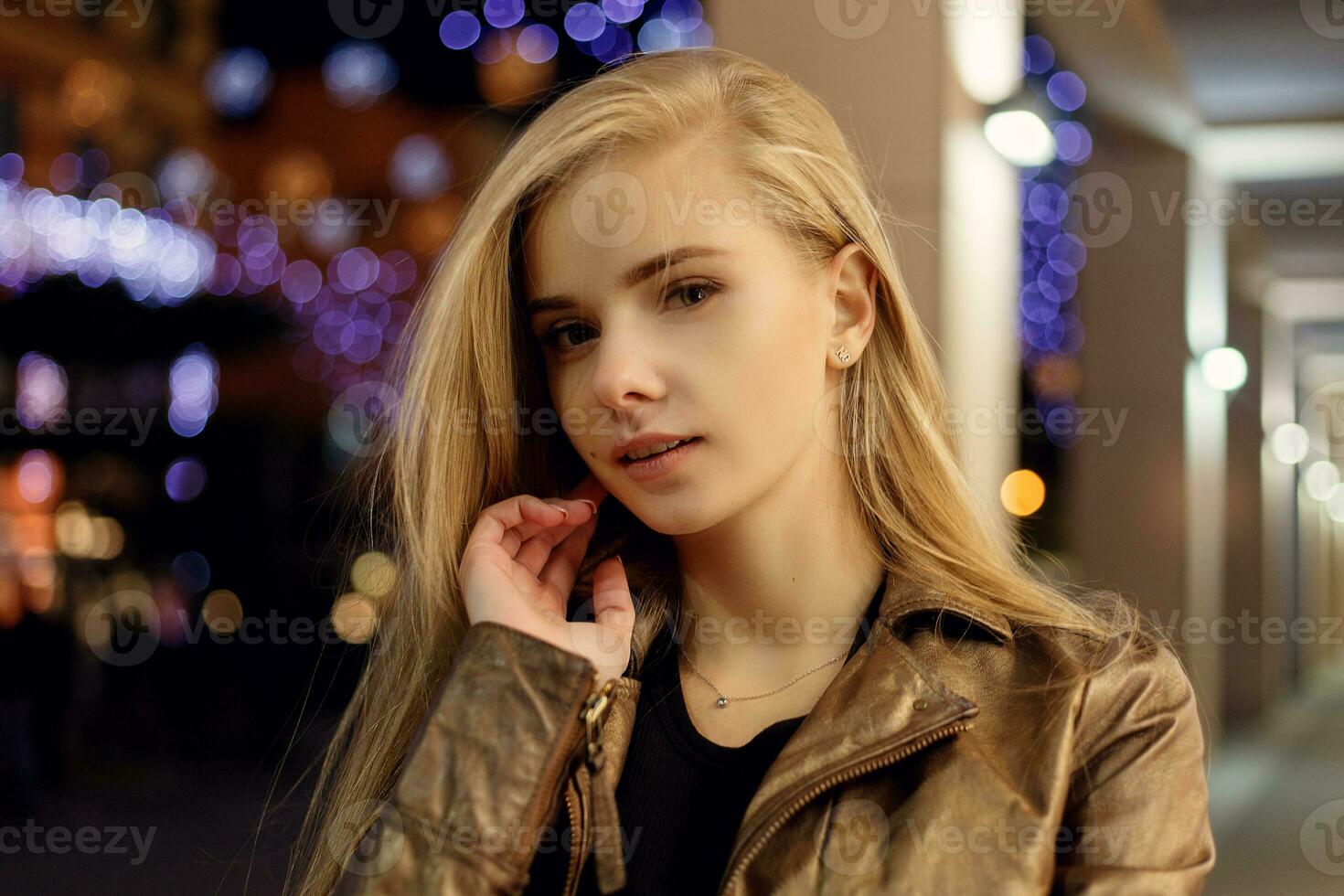 woman smiling in the night against evening lights bokeh photo