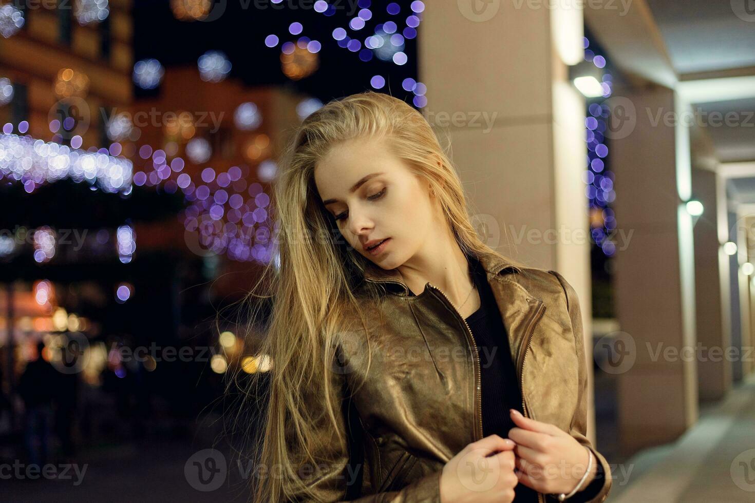 woman smiling in the night against evening lights bokeh photo