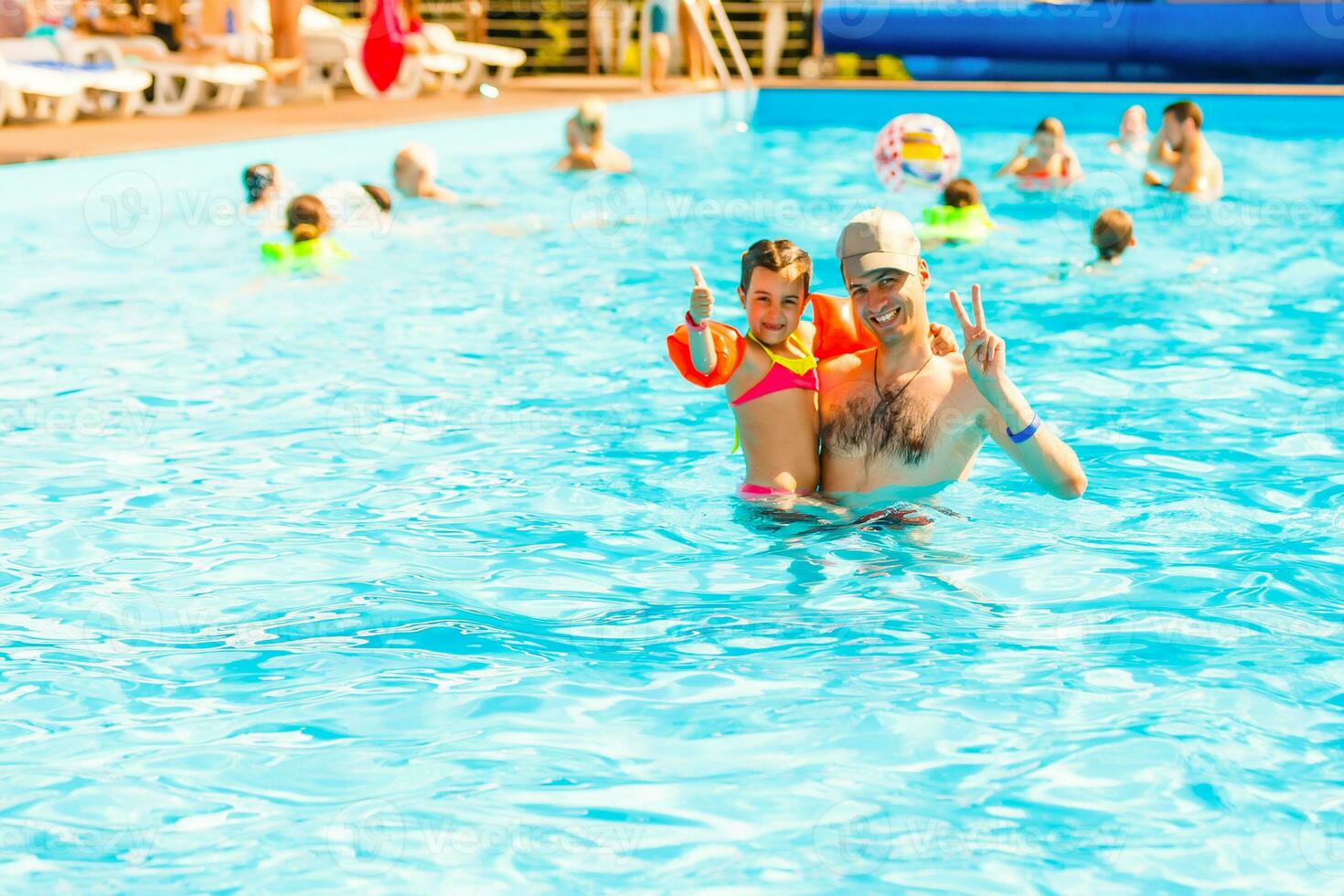 Father playing with his daughter in swimming pool photo