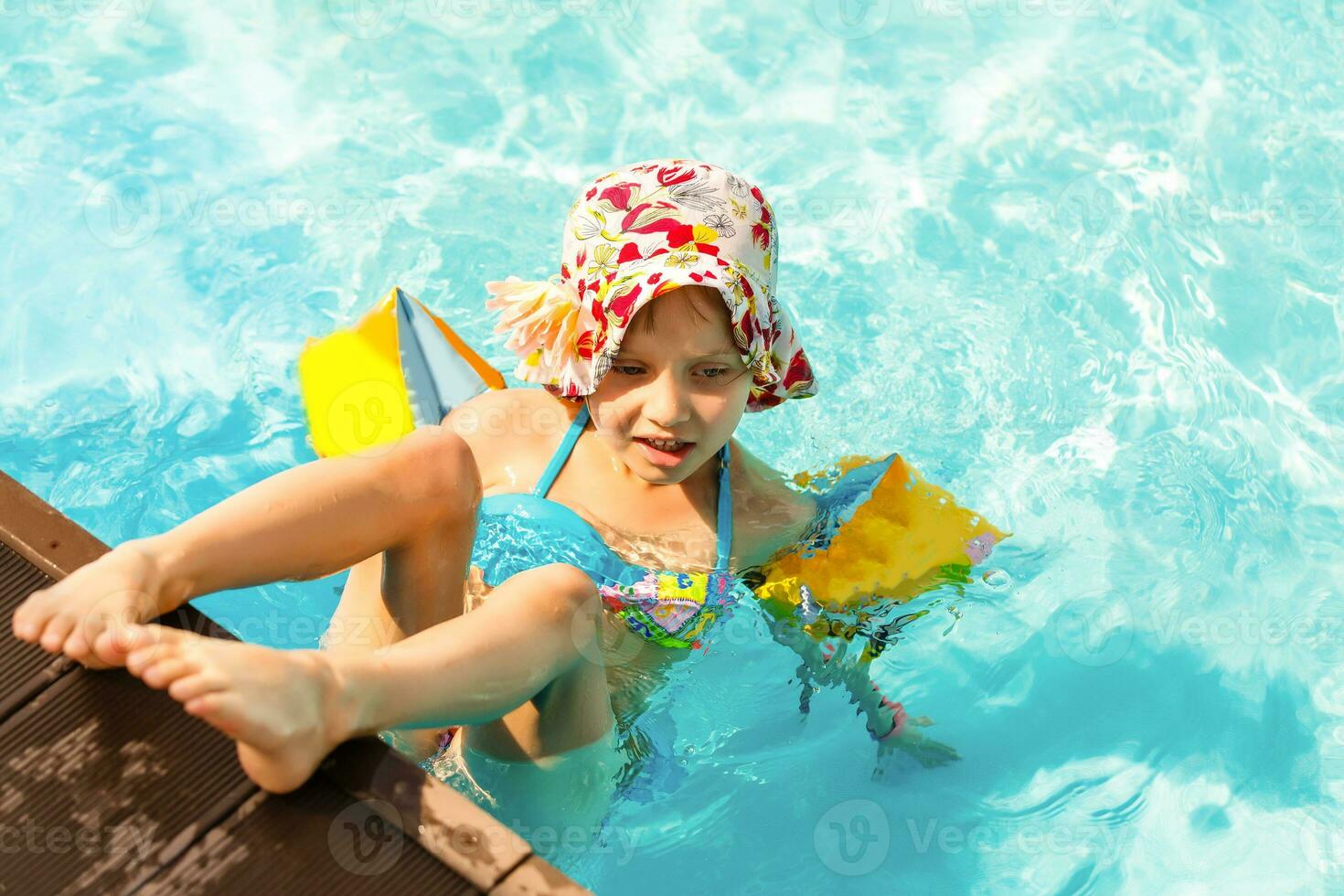 Cute toddler girl playing in swimming pool photo