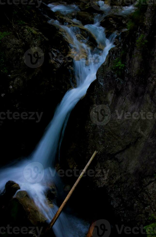 hermosa montaña cascada en oscuro colores. tatra nacional parque foto