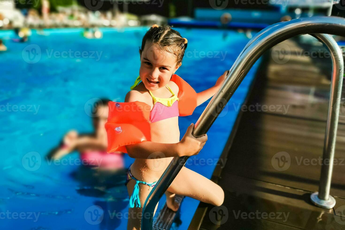 Cute toddler girl playing in swimming pool photo