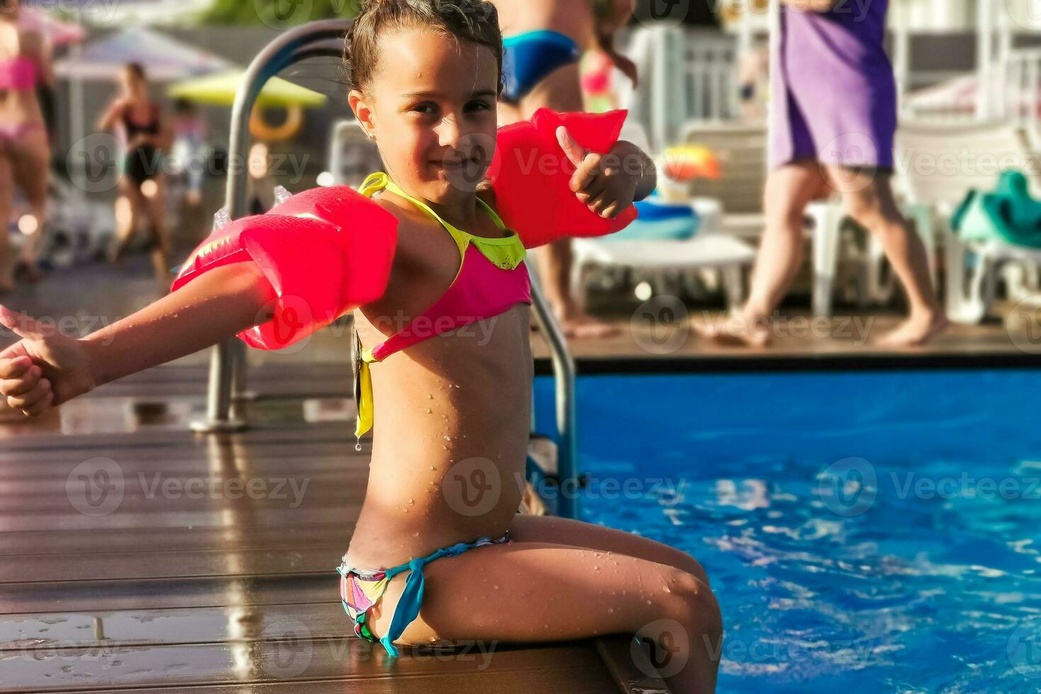 Cute toddler girl playing in swimming pool photo