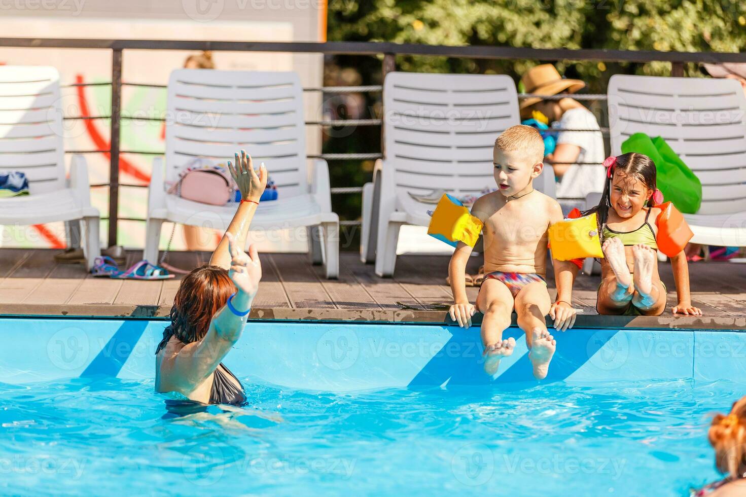 two women and their children in the pool photo