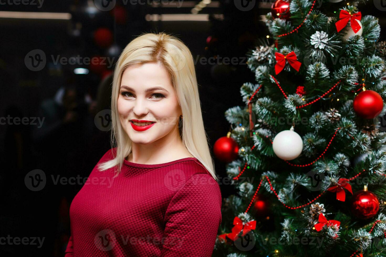 smiling woman near the Christmas tree. Fashionable luxury girl celebrating New Year. Beautiful luxury trendy blonde. photo